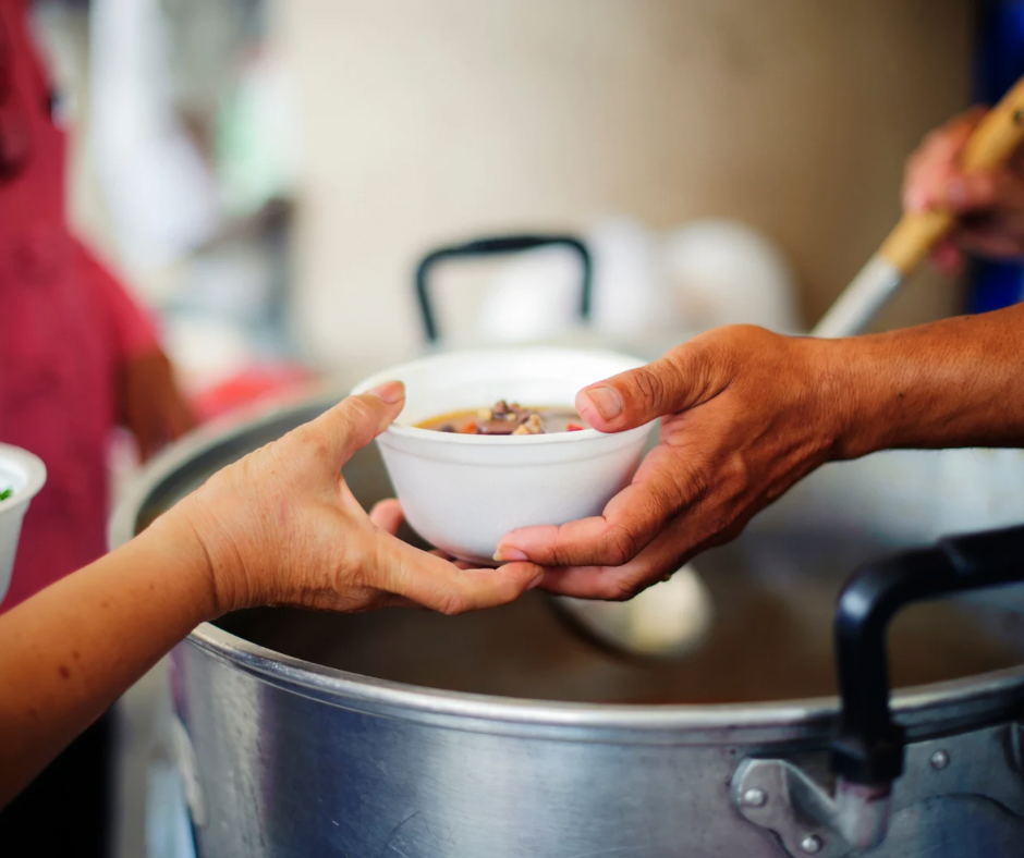 Hands exchanging a food pack — a symbol of exchange and community support